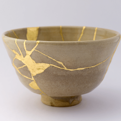 Kintsugi: eine Schale, die zerbrochen war. Die Risse und Bruchstellen sind dünn und z.T dick und sind Gold aufgefüllt